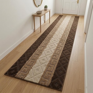May include: A rectangular runner rug with a geometric pattern in shades of brown, beige, and cream. The rug features a central cream-colored diamond pattern bordered by beige and dark brown bands. The rug is placed on a light-colored wooden floor.