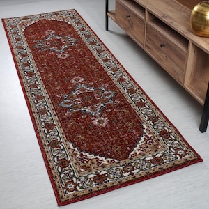 May include: A red runner rug with a traditional Persian design. The rug has a cream-colored border with intricate floral patterns. The center of the rug features a large, ornate diamond shape.