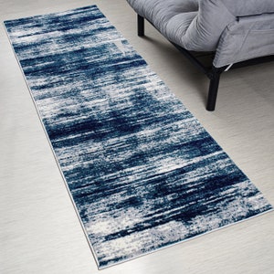May include: A blue and white abstract runner rug with a modern design. The rug has a long, narrow shape and is perfect for adding a touch of style to any room.