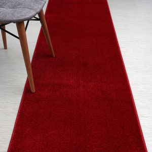 May include: A red carpet runner with a chair in the background.