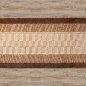 Pode incluir: Um tapete corredor castanho e bege com um design geom&eacute;trico. O tapete tem uma borda castanha e um centro bege com um padr&atilde;o repetitivo de quadrados.