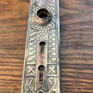 May include: A white ceramic mug with a black handle and the text "But First, Coffee" in a bold, black font. The mug is set against a blurred background, suggesting a cozy setting.