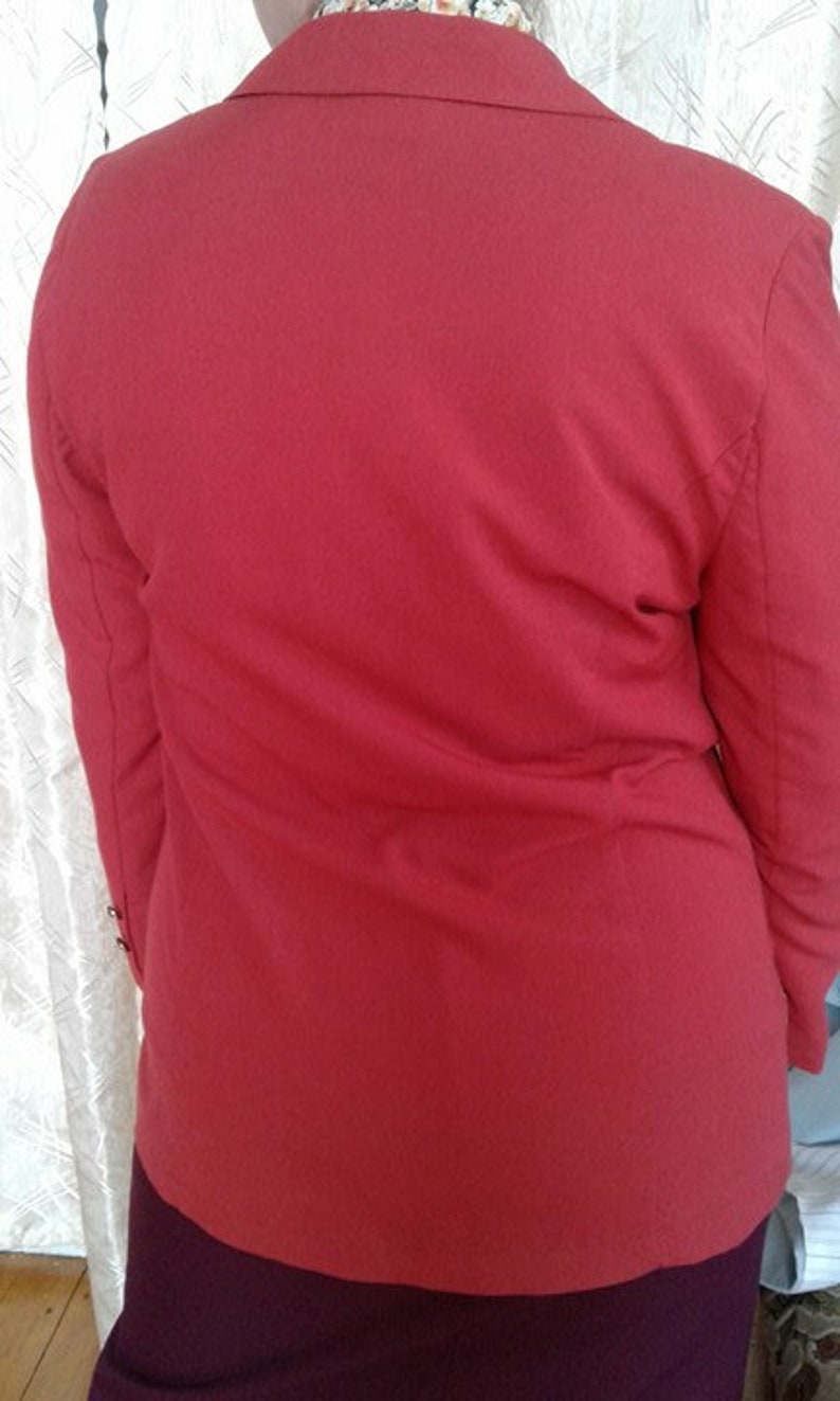 May include: A red blazer with a long sleeve and a collar. The blazer is made of a soft, comfortable fabric.