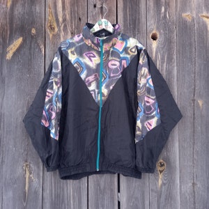 May include: Black windbreaker jacket with a colorful abstract print. The jacket has a teal zipper and a drawstring waist.