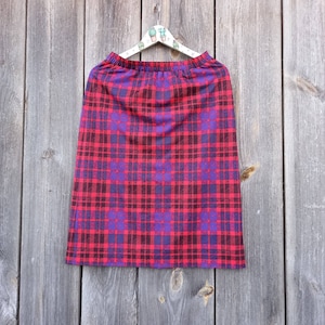 May include: A red and purple plaid skirt with a high waist and a straight silhouette.