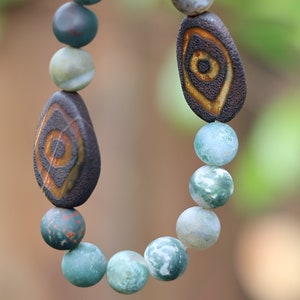Horrible pulsera de cuentas dZi de ágata india de dos ojos de 10 mm. Con un hermoso joyero Wajakaa ECO. Consisten en cartón con certificación FSC®
