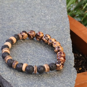 Op de afbeelding: Een armband met bruine en zwarte kralen. De armband is gemaakt van natuurlijke materialen en heeft een rustieke uitstraling.