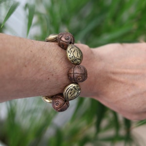 Metallook bead bronze almond shape beads with Metallook bead bronze round with dots.  a powerful way to express your individuality