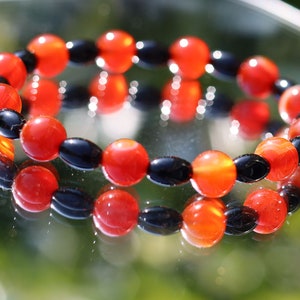 Carnelian red beaded bracelet with  Black Agate Barrel Beads. Agate enhances creativity and strengthens the intellect
