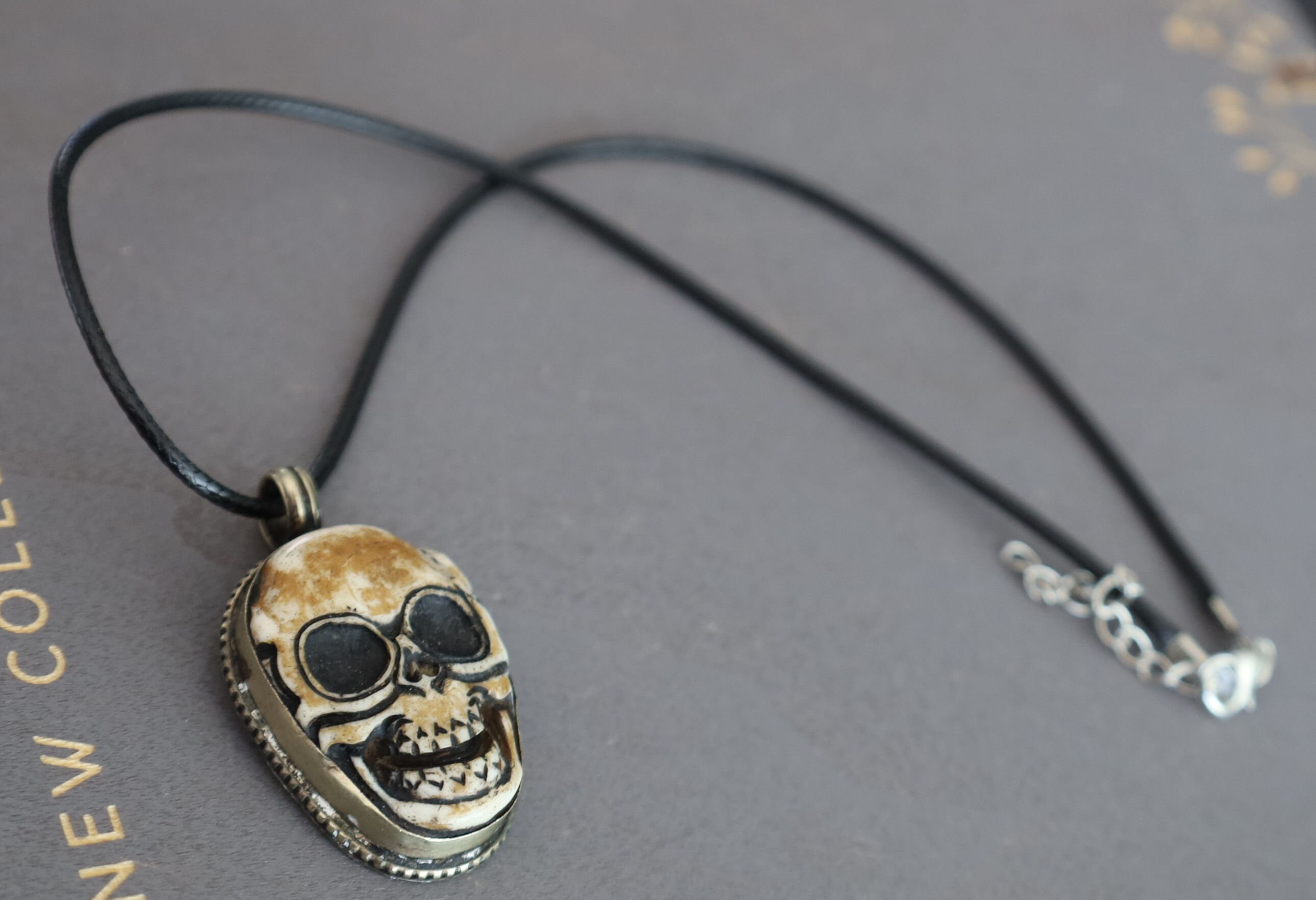 A bone skull amulet or pendant with metal mounting that originates from Nepal can hold various meanings and cultural significance.