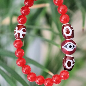 Big man 3x dzi with Carnelian beads and an Evil Eye Glass Bead. The stone helps to solve problems and release stress