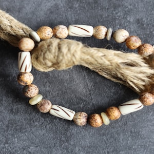 Schmuck aus Knochenedelsteinen. Natursteinperlen Leopardenhaut-Jaspisperlen mit wunderschönem handgefertigten weißen Knochen mit Verzierungen.