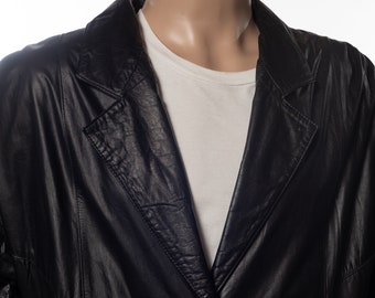 May include: A black leather jacket with a button closure and a classic collar. The jacket has a slightly oversized fit and a textured finish.