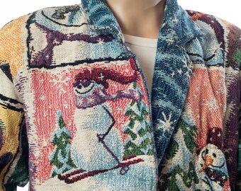 May include: A colorful woven jacket with a winter holiday theme. The jacket features a variety of winter scenes, including snowmen, trees, and snowflakes. The jacket has a button closure and a collar.