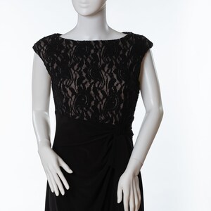 May include: A black lace and jersey dress with a fitted bodice and a flowing skirt. The dress has a scoop neckline and cap sleeves.