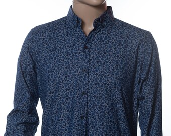 May include: A long-sleeved button-down shirt with a floral pattern in shades of blue and gray. The shirt is displayed on a mannequin, paired with blue boxer briefs. The shirt has a classic collar and buttoned cuffs.