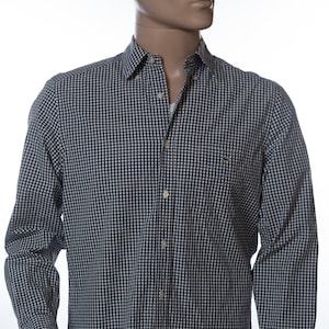 May include: A long-sleeved button-down shirt with a navy and white checkered pattern. The shirt has a classic collar, a chest pocket, and buttoned cuffs. The mannequin is also wearing blue underwear.