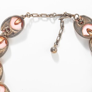 Puede incluir: Un collar de tono plateado con una cadena y un cierre. El collar est&aacute; hecho de eslabones ovalados con esmalte rosa y naranja.