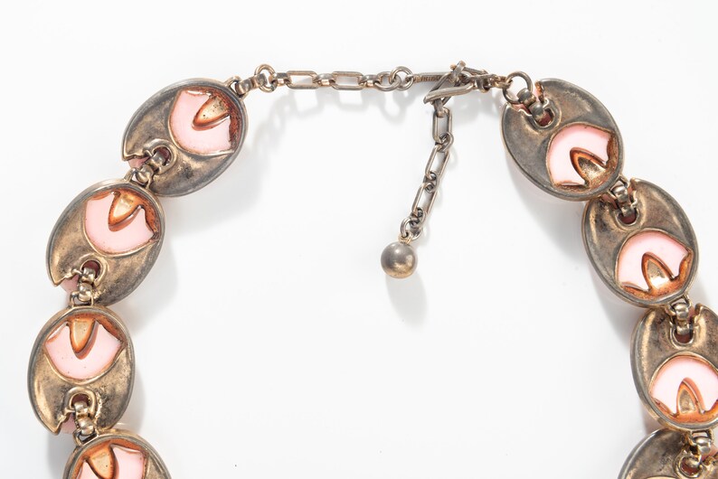 Puede incluir: Un collar de tono plateado con una cadena y un cierre. El collar est&aacute; hecho de eslabones ovalados con esmalte rosa y naranja.