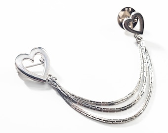 Può includere: Broche a forma di cuore in argento con una catena pendente composta da tre catene d'argento.