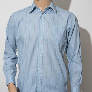 May include: A light blue long-sleeved button-down shirt with thin white and light blue stripes.