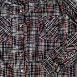 Pode incluir: Uma camisa de flanela xadrez com fecho de botões e dois bolsos no peito. A camisa é feita de um tecido macio e confortável e tem um caimento descontraído.