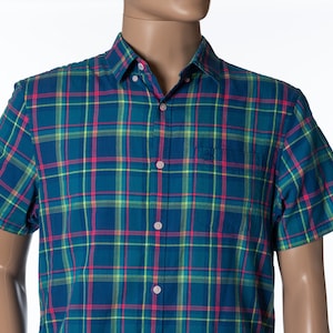 May include: A blue, green, yellow, and pink plaid short-sleeved button-down shirt.