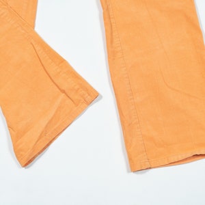 May include: A pair of wide-leg pants in a light orange color. The pants are made of a soft, textured fabric.