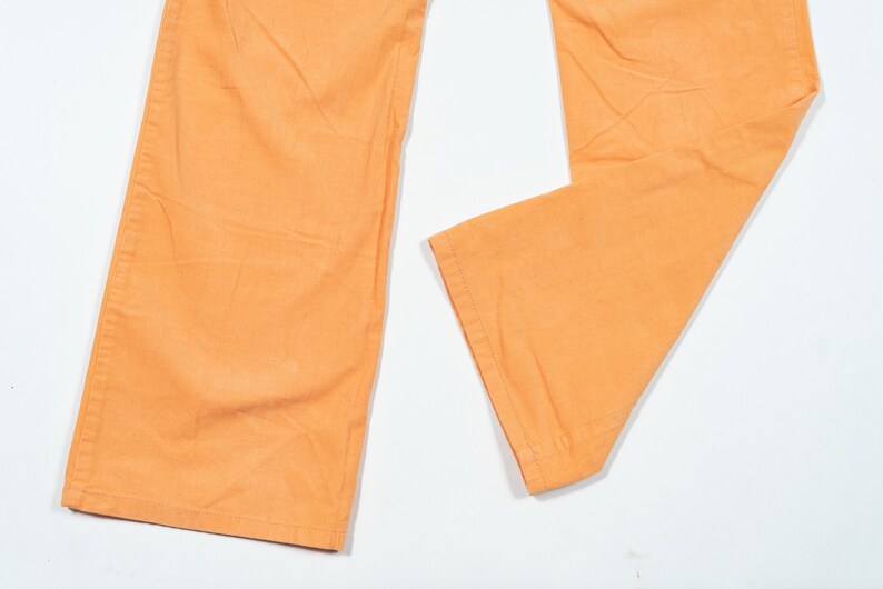 May include: A pair of wide-leg pants in a bright orange color. The pants are made of a soft, lightweight fabric and have a relaxed fit.