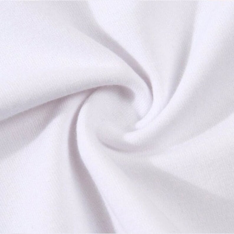 May include: Close-up of white fabric with a soft, textured appearance. The fabric is tightly woven, with visible ridges and a slight sheen, creating a swirling pattern. The image highlights the material's smooth surface and subtle variations in tone.