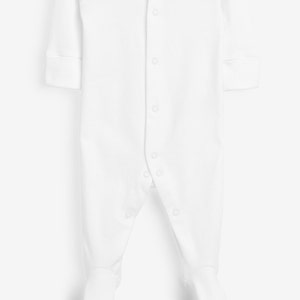 May include: A white baby sleeper with long sleeves and attached feet. The sleeper has a button-up front closure and is made of a soft, comfortable fabric. The cuffs on the sleeves are folded over.