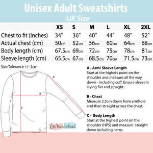 Puede incluir: Una sudadera blanca de manga larga con una tabla de tallas para sudaderas unisex para adultos. La tabla incluye medidas de pecho, cuerpo y manga en cent&iacute;metros para las tallas XS a 2XL. El texto de la imagen dice "Luss Wonderland".