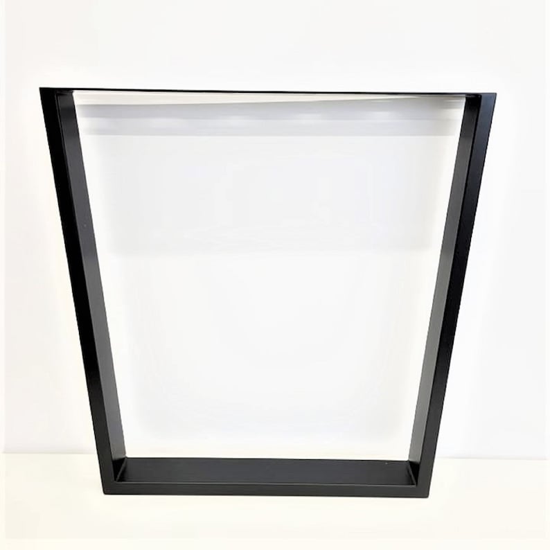 May include: Black metal table legs with a trapezoidal shape. The legs are made of a sturdy metal and have a black finish.