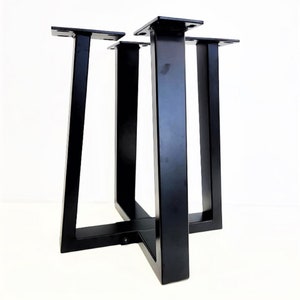 May include: Black metal table base with four legs and a square crossbar. The legs are angled and the base is sturdy.