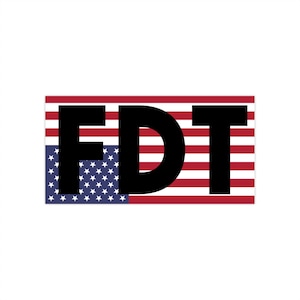 May include: A rectangular sticker with the letters "FDT" in bold black font. The letters are set against a design incorporating the American flag, with red and white stripes and a blue field of stars.