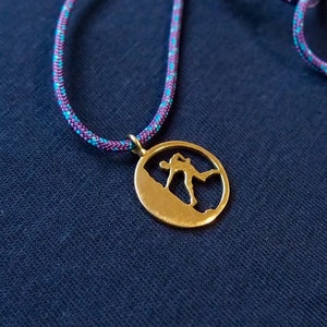 Brass climber silhouette pendant, with a sliding knot to adjust the length and a wide choice of cord colors