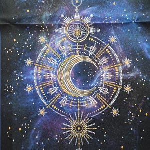 Pode incluir: Uma tela preta com um fundo de galáxia que apresenta um design geométrico dourado e branco com uma lua crescente e estrelas. O texto "The Symbol of the Fulfillment of Dreams" está na parte superior da tela.