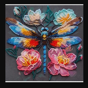 Può includere: Una libellula perlata con ali blu, gialle e rosse è circondata da fiori rosa e blu. La libellula e i fiori sono perlati su una tela grigio scuro.