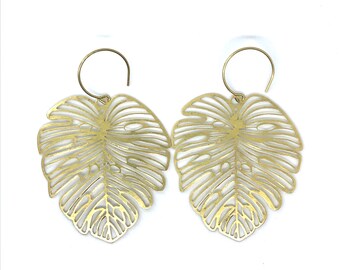 May include: Gold-tone earrings with a delicate, cutout leaf design. The leaves are shaped like monstera plants.