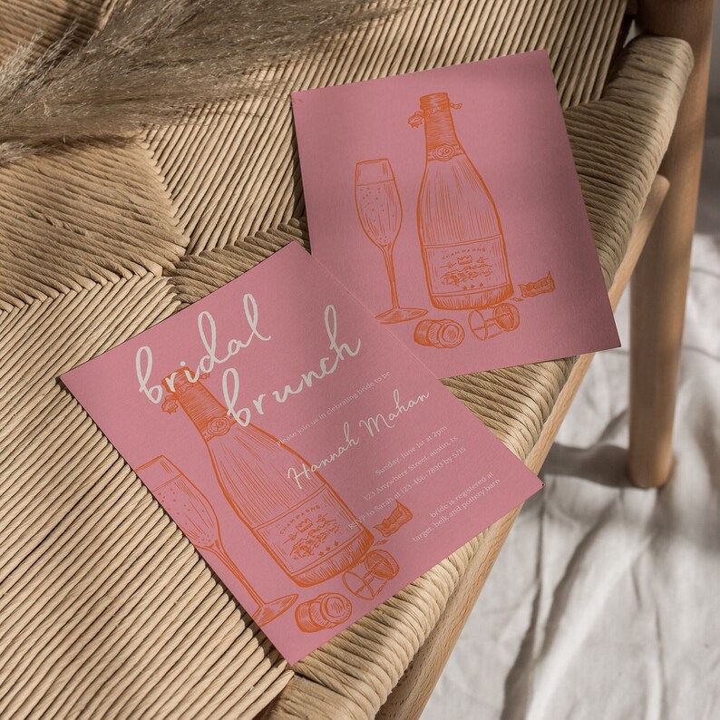 May include: Pink bridal brunch invitation with a hand-drawn illustration of a champagne bottle and glass. The invitation includes the text "bridal brunch" and "Hannah Mahan".