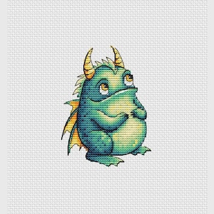 Puede incluir: Diseño de punto de cruz de un dragón de dibujos animados. El dragón es principalmente verde azulado y amarillo, con cuernos y detalles amarillos. Tiene ojos grandes y expresivos y posa con las manos juntas frente a su vientre. El fondo es gris claro.