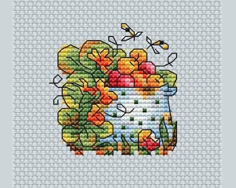 May include: A cross-stitch pattern of a white ceramic bowl filled with orange, yellow, and red fruit. Green vines with leaves surround the bowl and two yellow and black bees fly above.