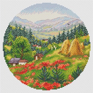 Könnte beinhalten: Eine Kreuzstich-Landschaftsszene in einem kreisförmigen Rahmen. Die Szene zeigt eine lebendige Landschaft mit grünen Bäumen, roten Blumen und kleinen Häusern. Zwei Heuhaufen stehen auf einem Feld, mit Bergen und blauem Himmel im Hintergrund.