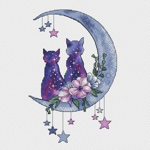 Peut inclure: Deux chats violets et bleus avec un motif de galaxie sont assis sur une lune croissante avec des fleurs roses et blanches. La lune est décorée d'étoiles suspendues.