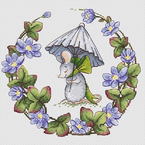 May include: A gray mouse holding a blue and green umbrella, surrounded by a wreath of blue flowers and green leaves.