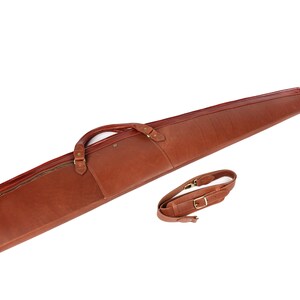 May include: A brown leather gun case with a zippered pocket and a shoulder strap.