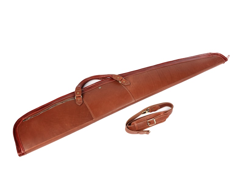 May include: A brown leather gun case with a zippered pocket and a shoulder strap.