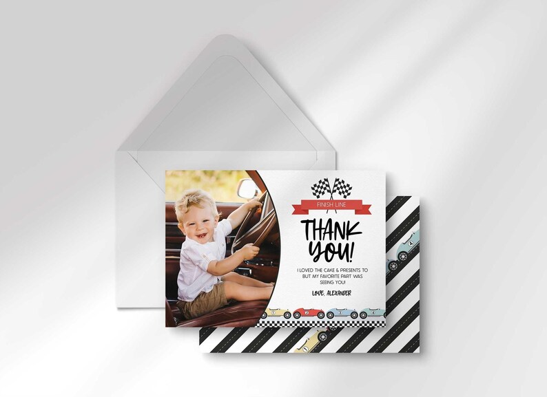 Alexander's race car-themed thank you photo card layered in front of its matching envelope, with the black and white diagonal race-stripe back design peeking out behind it.