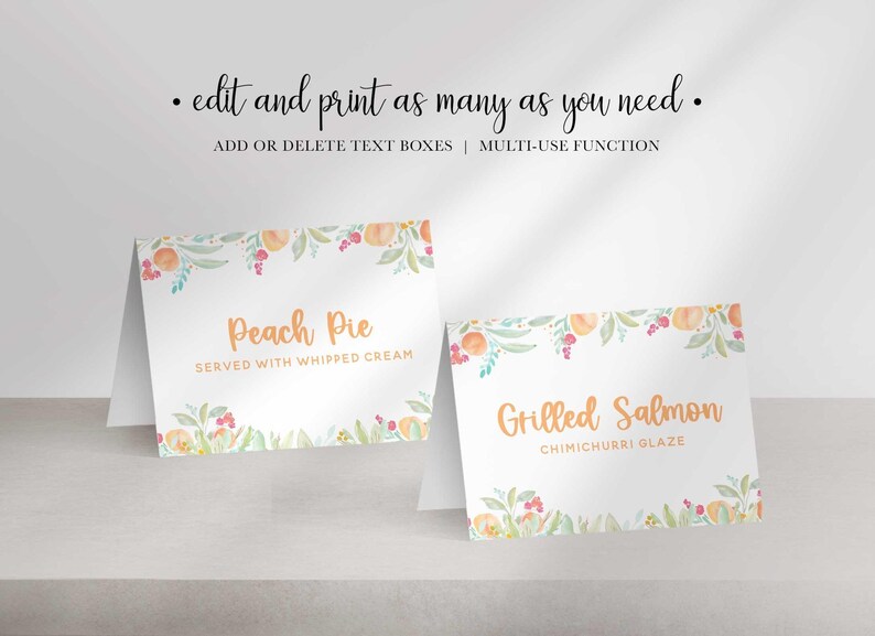 Two folded white paper place cards with watercolor peach borders display the text Peach Pie and Grilled Salmon in orange font.