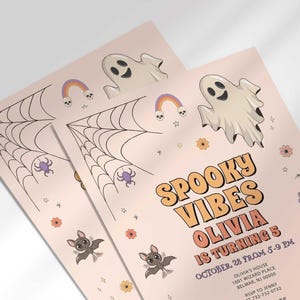 Angled stack of two prints of the 'Spooky Vibes' Halloween invitation for Olivia's 5th birthday, showing the print quality and ghost, bat, and pumpkin illustrations.